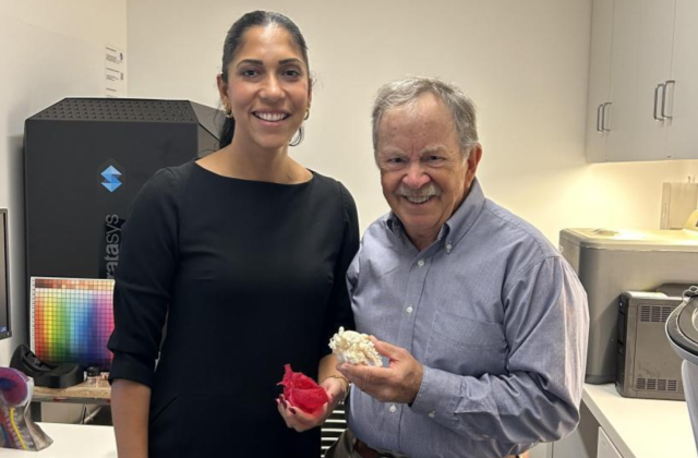 Two people in lab holding heart models